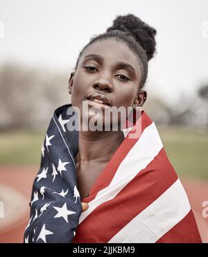 En prenant une chance sur moi-même. Une belle jeune athlète féminine avec le drapeau américain enveloppé autour d'elle. Banque D'Images