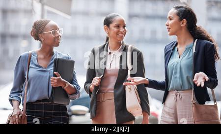 Shes les a toujours intrigués. Un groupe de jeunes femmes d'affaires qui parlent dans un contexte urbain. Banque D'Images