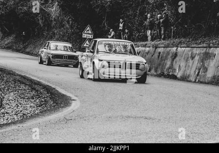 Une photo en niveaux de gris d'une BMW 2002 sur un vieux rallye de voitures de course Banque D'Images