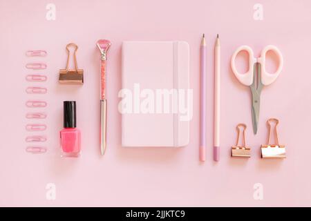 Cahier de notes couverture et accessoires d'école rose sur rose pastel, vue de dessus, maquette de manuel. Gilly Workplace avec ciseaux, crayons, stylo, trombones et Banque D'Images