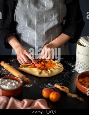 Photographie alimentaire de tarte à l'abricot, galette, gâteau, préparation, mains Banque D'Images