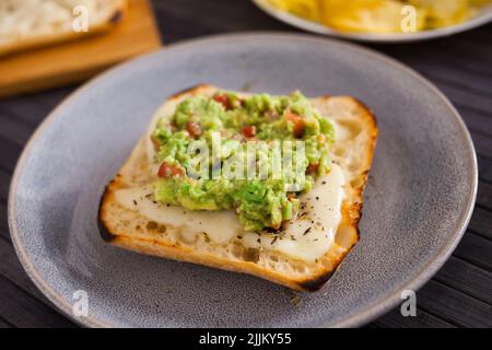 petit déjeuner sain. pain de ciabatta italien grillé avec fromage fondu et purée d'avocat Banque D'Images