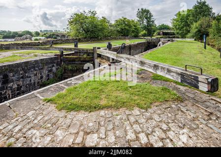 Stegneck Lock, l'écluse 35 sur le canal Leeds & Liverpool près de Gargrave, se trouve à côté d'un pont d'accès à la voie piétonne qui traverse le canal lui-même. Banque D'Images