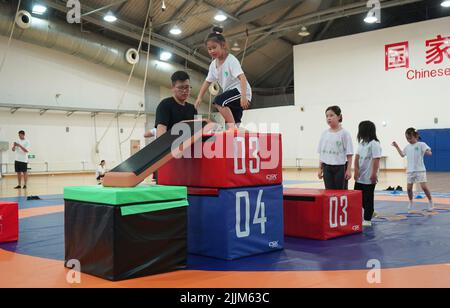 Pékin, Chine. 26th juillet 2022. Les enfants participent à un entraînement physique dans le cadre d'un programme de camp d'été au Centre national olympique des sports de Pékin, capitale de la Chine, 26 juillet 2022. Credit: Jin Haoyuan/Xinhua/Alamy Live News Banque D'Images