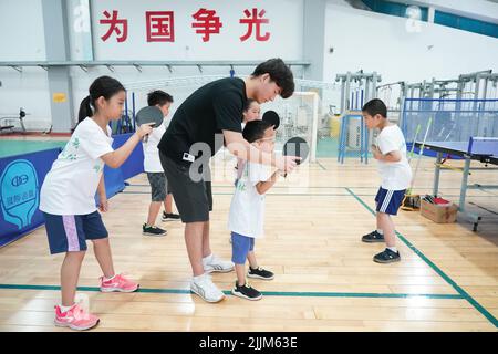 Pékin, Chine. 26th juillet 2022. Les enfants pratiquent le tennis de table dans le cadre d'un programme de camp d'été au Centre national olympique des sports de Pékin, capitale de la Chine, 26 juillet 2022. Crédit: REN Chao/Xinhua/Alay Live News Banque D'Images