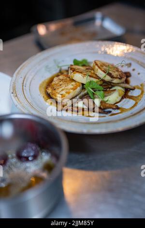 Un foyer peu profond de ballotine de poulet, de purée de pommes de terre fumée, de chanterelle sautées et de jus de veau Banque D'Images