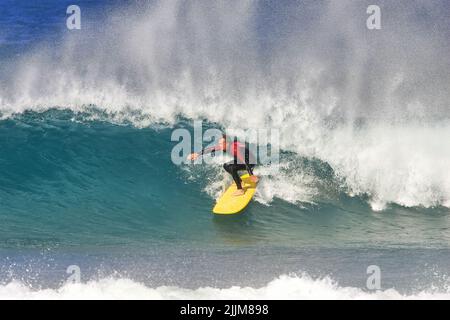 Une surfeuse de longue date à bord d'une vague à Fistral Beach Newquay, Royaume-Uni Banque D'Images