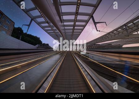 Une photo à angle bas d'un escalier mécanique contre les bâtiments et d'un magnifique ciel de coucher de soleil Banque D'Images