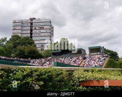 Wimbledon, Grand Londres, Angleterre, 02 juillet 2022: Championnat de tennis de Wimbledon. Court extérieur plein de spectateurs et un bloc d'appartements à proximité Banque D'Images