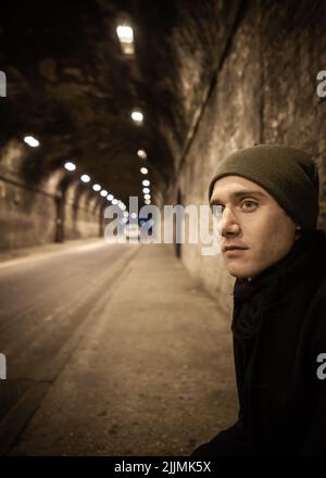 Anxiété urbaine. Un homme solitaire attend anxieusement dans un cadre urbain tard dans la nuit. À partir d'une série d'images avec les mêmes modèles. Banque D'Images