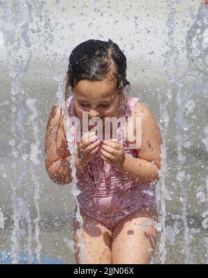 Raleigh, Caroline du Nord, États-Unis. 27th juillet 2022. ROSIE DILDAY, âgée de 4 ans, se rafraîchit en passant par les arroseurs de coussins dans le John Chvis Memorial Park, alors que les températures atteignent à nouveau le milieu des années 90 à Raleigh, en Caroline du Nord. Une grande partie du pays a également connu des températures supérieures à la moyenne tout au long du mois de juillet. (Image de crédit : © Bob Karp/ZUMA Press Wire) Banque D'Images