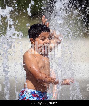 Raleigh, Caroline du Nord, États-Unis. 27th juillet 2022. Le VERT D'AYDEN, âgé de 8 ans, se rafraîchit en passant par les arroseurs de protection dans le John Chvis Memorial Park, alors que les températures atteignent à nouveau le milieu des années 90 à Raleigh, en Caroline du Nord. Une grande partie du pays a également connu des températures supérieures à la moyenne tout au long du mois de juillet. (Image de crédit : © Bob Karp/ZUMA Press Wire) Banque D'Images