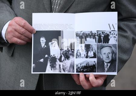 Un deuil tenant un ordre de service à l'extérieur de l'église des pâturages verts, Ballymena, qui a tenu un service d'action de grâce pour le fondateur de Wrightbus, Sir William Wright. Banque D'Images