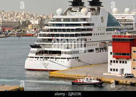 Athènes, Grèce - 2022 mai : bateau de croisière de luxe encore Seabourn amarré dans le port du Pirée, avec un bateau pilote retournant au port Banque D'Images