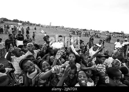 Un portrait en niveaux de gris des enfants africains qui se posent sur le terrain de jeu de l'école à Johannesburg, en Afrique du Sud Banque D'Images