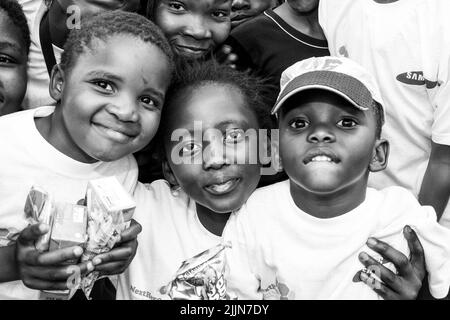 Un portrait en niveaux de gris des enfants africains qui se posent sur le terrain de jeu de l'école à Johannesburg, en Afrique du Sud Banque D'Images