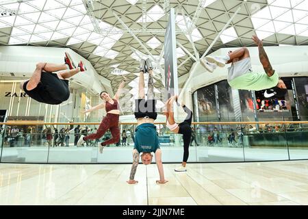 UTILISATION ÉDITORIALE SEULEMENT la gymnaste olympique Nile Wilson (au centre) avec des gymnastes (à gauche et à droite) Ash Watson, Joanna Wilson, Sophie Brace et Luke Stoney se produit jeudi au centre commercial Westfield London pour célébrer le nouveau jour de l'essai national. Date de la photo: Mercredi 27 juillet 2022. Nile et une équipe de tumblers ont réalisé des cascades telles que le Human Bowling ball, un parcours d'obstacles et des tours de piste aérienne dans l'Atrium de Westfield, offrant un entraînement de cascades gymnastiques un-à-un aux passants. Le crédit photo devrait se lire: Matt Crossick/PA Wire Banque D'Images