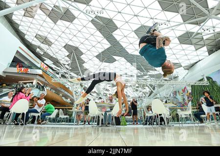 UTILISATION ÉDITORIALE SEULEMENT la gymnaste olympique Nile Wilson (à droite) et la gymnaste Sophie Brace se produit au Westfield London Shopping Centre pour célébrer le nouveau jour de l'essai national jeudi. Date de la photo: Mercredi 27 juillet 2022. Nile et une équipe de tumblers ont réalisé des cascades telles que le Human Bowling ball, un parcours d'obstacles et des tours de piste aérienne dans l'Atrium de Westfield, offrant un entraînement de cascades gymnastiques un-à-un aux passants. Le crédit photo devrait se lire: Matt Crossick/PA Wire Banque D'Images