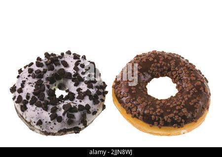 Vue rapprochée des beignets de chocolat parsemés de noix isolées sur fond blanc. Banque D'Images