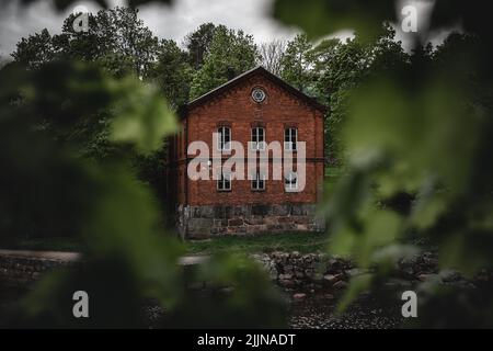 Une belle photo d'une maison en briques rouges située dans la forêt luxuriante Banque D'Images