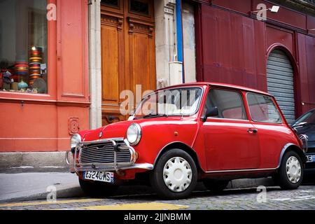 Un vieux mini-parking Cooper rouge sur le côté de la rue à Londres Banque D'Images