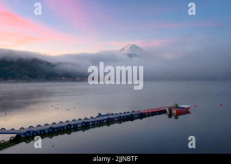 Mt. Fuji au-dessus du lac Kawaguchi, au Japon, avec du brouillard qui se balade à l'aube. Banque D'Images