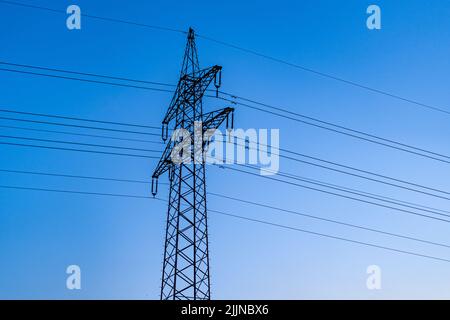 Un poteau électrique contre le ciel bleu Banque D'Images