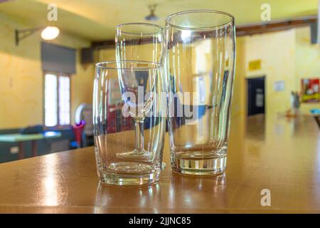 trois verres vides de différentes tailles et formes sur le comptoir d'un lieu avec un accent sur les verres Banque D'Images