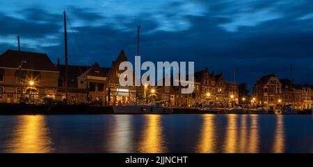 Une photo à angle bas de maisons près de l'eau la nuit à Hoorn, pays-Bas Banque D'Images