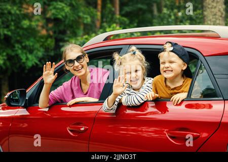 voyage en famille. mère avec enfants voyageant en voiture. s'inclinant de la fenêtre Banque D'Images