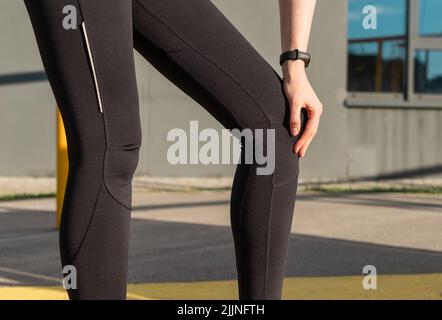 Athlète souffrant de douleurs au genou. Femme touchant une jambe douloureuse. Ligaments tentagés, déchirure du ménisque, tendinite. Problèmes de santé, conditions médicales concept. Photo de haute qualité Banque D'Images