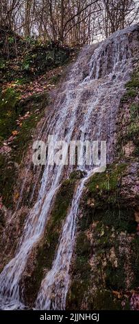 Un plan vertical d'une petite cascade qui coule sur les rochers Banque D'Images