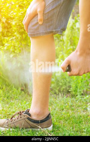 Jeune homme utilisant un insectifuge contre une sorte d'insectes, concept de santé Banque D'Images