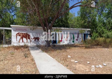 Bloc de douche et toilettes joliment décoré avec des éléphants et d'autres scènes. Plage d'Eristos, Tilos, mai 2022. Banque D'Images