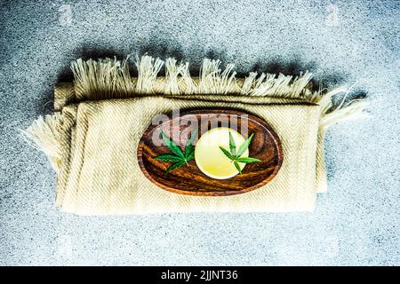 Vue en hauteur d'une feuille de marijuana, d'un savon sur un porte-savon et d'un chemin de table plié Banque D'Images