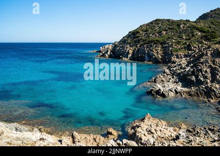 Un cliché aérien de paysage marin magnifique entouré de collines verdoyantes et de rochers en Sardaigne Banque D'Images