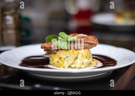 Appétissant nourriture sur une assiette blanche dans un restaurant. Faible profondeur de champ de viande de canard grillée avec pommes de terre gratin et sauce. Banque D'Images