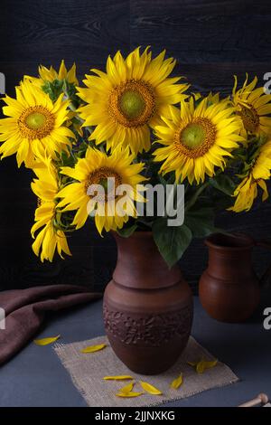 Encore la vie avec un bouquet de tournesols sur une table grise Banque D'Images