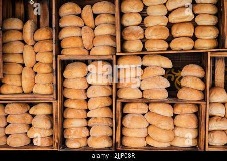 Pains de pain frais placés sur des étagères en bois dans le bakehouse en journée Banque D'Images