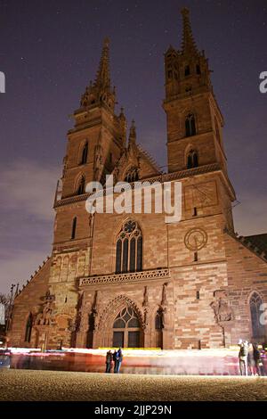 Une vue verticale des personnes qui prennent des photos de la cathédrale de Bâle Minster à Bâle, en Suisse, sur un fond de ciel étoilé Banque D'Images