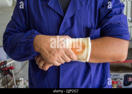 Image d'un homme de main avec une plaie bandée sur son bras. Référence aux accidents du travail Banque D'Images