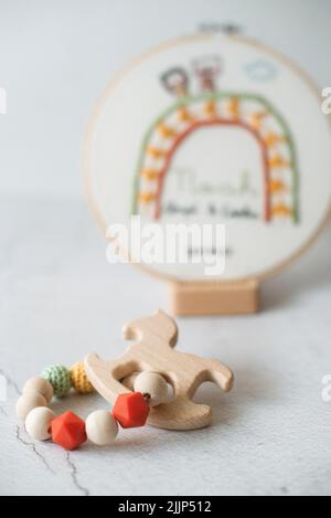 Gros plan d'un panier à broderie et d'un jouet de dentition sur une table Banque D'Images