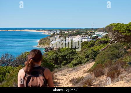 Une vue arrière d'une randonneur aventureuse randonnée sur la colline de sable sur la côte Banque D'Images