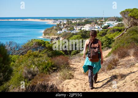 Une vue arrière d'une randonneur aventureuse randonnée sur la colline de sable sur la côte Banque D'Images