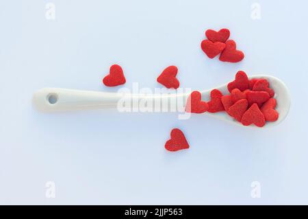 Vue en hauteur d'une cuillerée d'arrosettes en forme de cœur rouge sur une table Banque D'Images