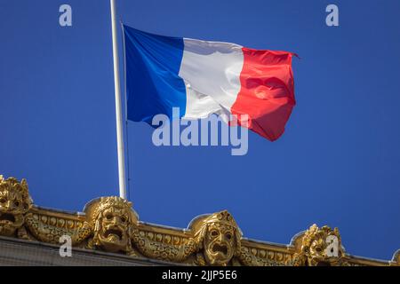Drapeau français serpentant au-dessus des gargouilles dans l'opéra parisien, France Banque D'Images