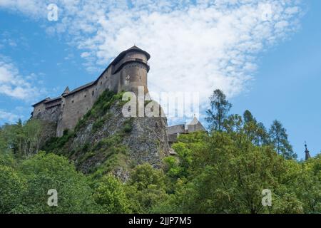 Vue sur les murs du château d'Orava. Nuages effilochés. Une colline surcultivée avec des arbres Banque D'Images