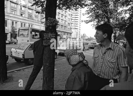 Bucarest, Roumanie, janvier 1990. Passerby lisant une plaque commémorative pour une maman de 24 ans abattu dans le centre historique, l'une des premières victimes de la révolution anticommuniste roumaine de décembre 1989. Banque D'Images