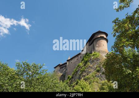 Vue sur les murs du château d'Orava. Nuages effilochés. Une colline surcultivée avec des arbres Banque D'Images