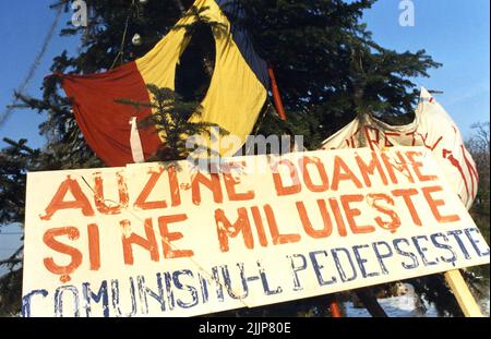 Bucarest, Roumanie, janvier 1990. Mémorial pour les victimes de la révolution anticommuniste roumaine de décembre 1989 sur la place Romana, l'un des points clés du soulèvement. Drapeau roumain coupé avec l'emblème socialiste, un symbole anticommuniste pendant la Révolution roumaine de 1989. Signez disant «nous entendre, Seigneur et avoir miséricorde, punir le communisme». Banque D'Images